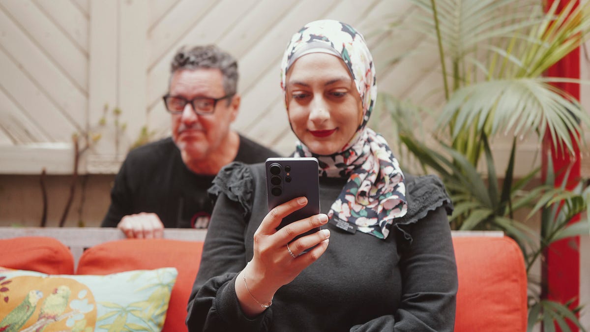 image of a creepy man looking at a phone at MWC 2026