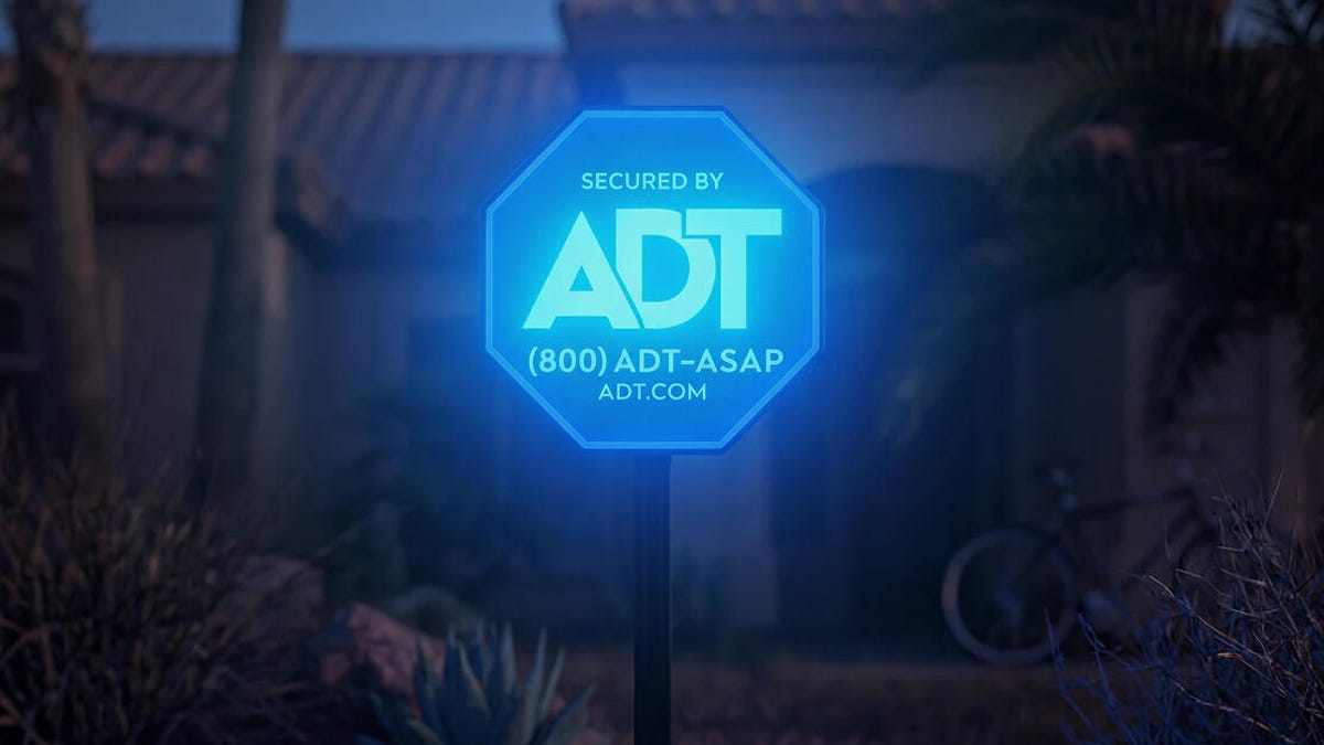ADT's Live light sign light in the dark in front of a house.