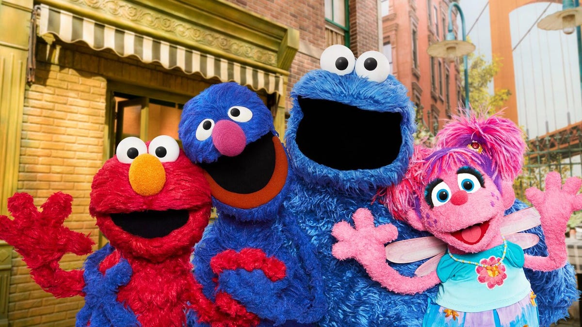 Still from Sesame Street showing Elmo, Grover, Cookie Monster and Abby Cadabby.